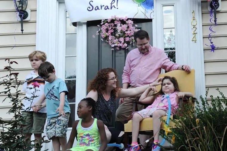 Little Sarah Murnaghan (right), the 11-year-old double-lung transplant recipient, meets the media with the rest of her family from the front stoop of the family home in Newtown Square after being released from the hospital Aug. 27, 2013.  Parents are Fran and Janet, with brothers (from left) Sean, 7, Finn, 5 and sister Ella, 8.  ( CLEM MURRAY / Staff Photographer )