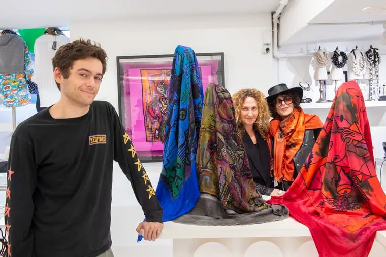 From the left are Jesse Weinstein, his mother Ellen Shepp Weinstein, and his grandmother Joan Shepp in Joan's Center City store on Nov. 5, 2019. They are surrounded by scarves he designed, which are featured in his grandmother's Chestnut St. boutique, Joan Shepp.