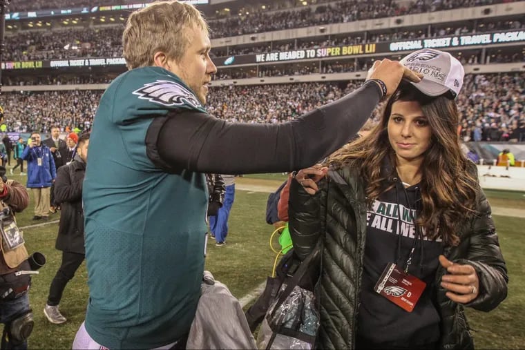 Eagles quarterback Nick Foles gives his wife, Tori Moore, a conference champions hat during the celebration after the Eagles beat the Vikings in the NFC championship game.