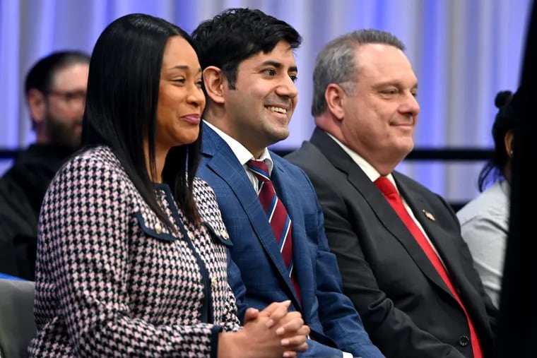 Jamila H. Winder (from left), Neil Makhija, and Thomas DiBello are seated together on stage at the Montgomery County Community College gymnasium Wednesday, Jan. 3, 2024, during ceremonies before they were sworn in as Montgomery County's new Board of Commissioners.