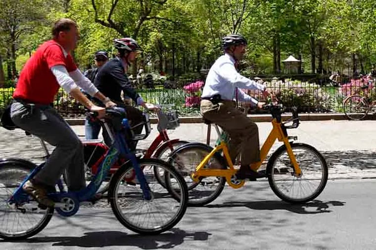 Mayor Michael Nutter, right, pedals a bike along 18th Street as he meets with vendors of bike-share equipment at Rittenhouse Square in Philadelphia on April 30, 2013. ( DAVID MAIALETTI  / Staff Photographer )