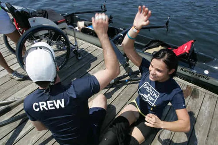 Augusto Perez (left) high-fives his partner, Oksana Masters. They were the team from Louisville, Ky., that beat Scott Brownand Jacqui Kapinowski in the category of 1,000-meter &quot;torso and arms&quot; race on the Schuylkill as part of the Bayada Regatta, a rowing competition for those with paralyzed limbs.