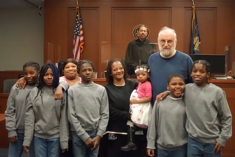 From left, Kash'ae, Kiaira, Flora (one of her biological children), Rah'mir, Flora (holding Amyah), Mark, Chase, and Zah'mir on the day Amyah was adopted.
