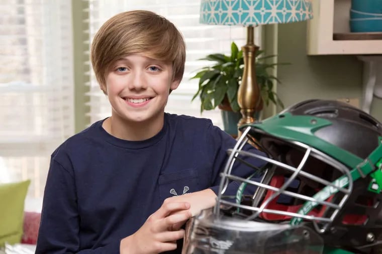 Braeden Lange, 12, at home with the lacrosse helmet he received from his mentor.