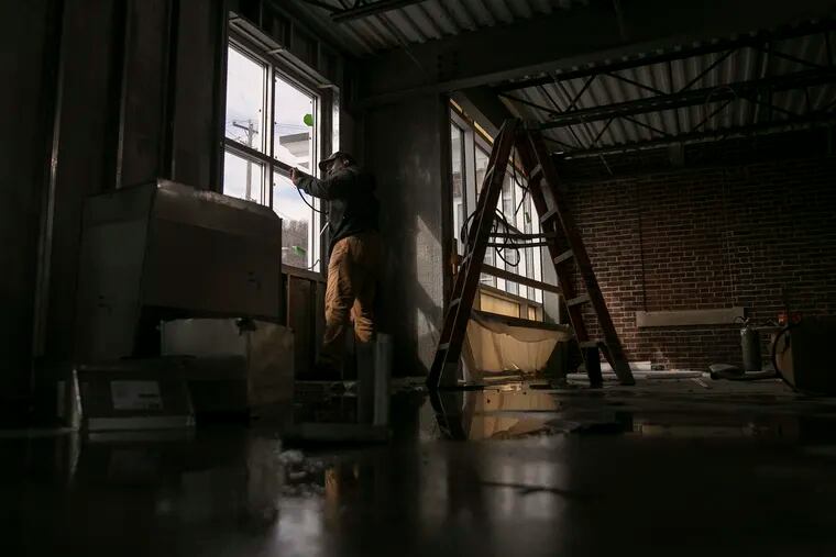Howard Roberts works on the windows inside the old steel mill building that is being reconstructed to become the nth Innovation Center in Coatesville, Pa. on Tuesday, Feb. 23, 2021.