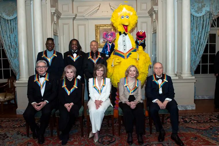 Front row from left, 2019 Kennedy Center Honorees Michael Tilson Thomas, Linda Ronstadt, Sally Field, Joan Ganz Cooney, and Lloyd Morrisett, back row from left, Philip Bailey, Verdine White, Ralph Johnson, and characters from "Sesame Street," Abby Cadabby, Big Bird, and Elmo pose for a group photo following the Kennedy Center Honors State Department Dinner at the State Department on Saturday, Dec. 7, 2019, in Washington. (AP Photo/Kevin Wolf)