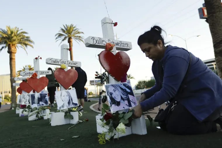 Cece Navarrette places flowers Friday at a cross for her cousin, Bailey Schweitzer, who was among those killed during the mass shooting in Las Vegas.
