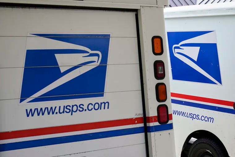 Mail delivery vehicles are parked outside a post office in Boys Town, Neb.
