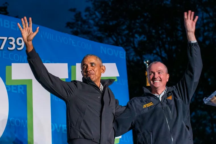 Former U.S. President Barack Obama, left, and New Jersey Gov. Phil Murphy wave at attendees after taking part in an early vote rally on Oct. 23, 2021 in Newark, New Jersey. People are heading to the polls in New Jersey for early voting as Murphy faces Republican challenger Jack Ciattarelli. (Eduardo Munoz Alvarez/Getty Images/TNS)