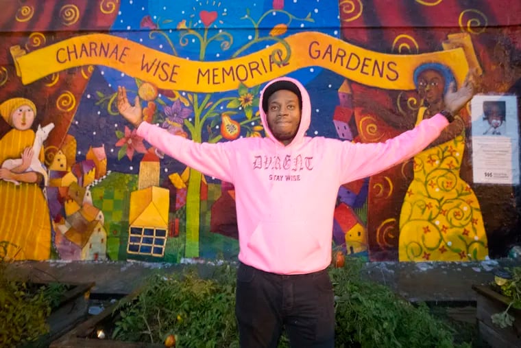 Dante Hailey stands triumphantly at the mural at the Charnae Wise Memorial Garden on Oct. 22, 2019. He and his sister were starved as children.  Dante survived.