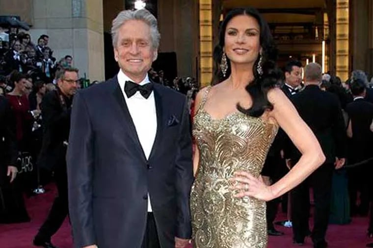 FILE - In this Feb. 24, 2013 file photo, actors Michael Douglas, left, and Catherine Zeta-Jones arrive at the Oscars at the Dolby Theatre, in Los Angeles. According to her publicist on Monday, April 29, 2013, Zeta-Jones has pro-actively checked into a health care facility. Previously, she has said that she is committed to periodic care in order to manage her health in an optimum manner. (Photo by Carlo Allegri / Invision / AP, File)