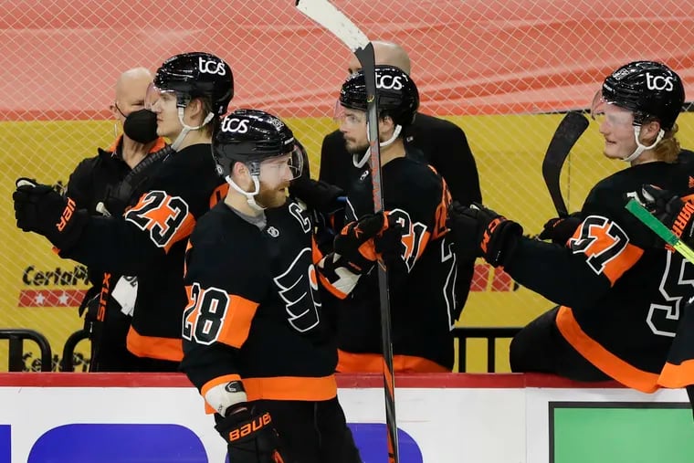 Flyers left winger Claude Giroux celebrates his third period game-tying goal with his teammates against the New Jersey Devils on Sunday.
