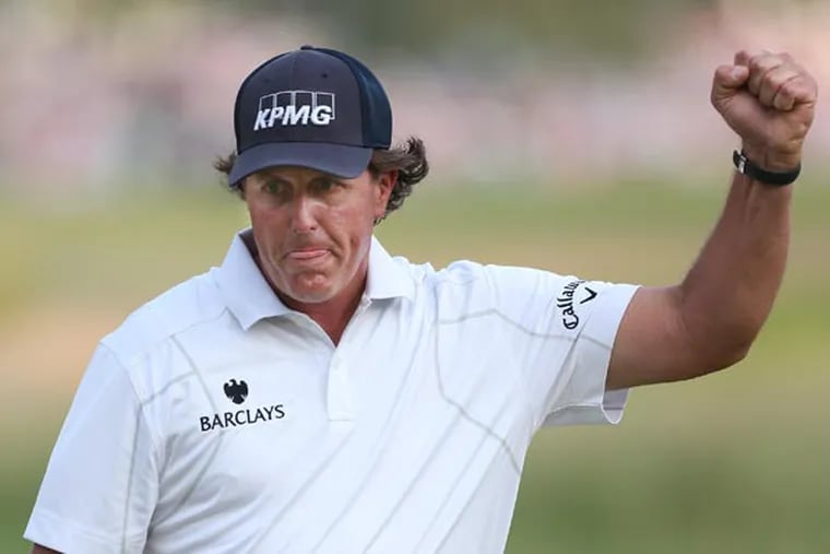 Phil Mickelson celebrates after dropping the birdie putt on 17. (Michael Bryant/Staff Photographer)