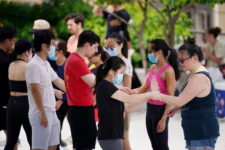 Miette Lau (left), a student at the Philadelphia Wing Chun Kung Fu School, helps Jennifer Phuong practice a wrist-grab escape during one of the Philly Fighting Asian Hate self-defense classes at the Rail Park in Philadelphia on Saturday.