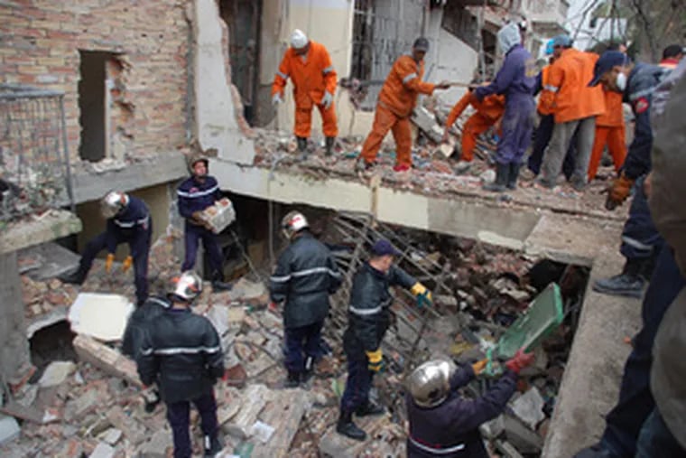 Rescuers work to clear rubble at a U.N building in Algiers, a day after twin bombings. The death toll rose to 31 yesterday.