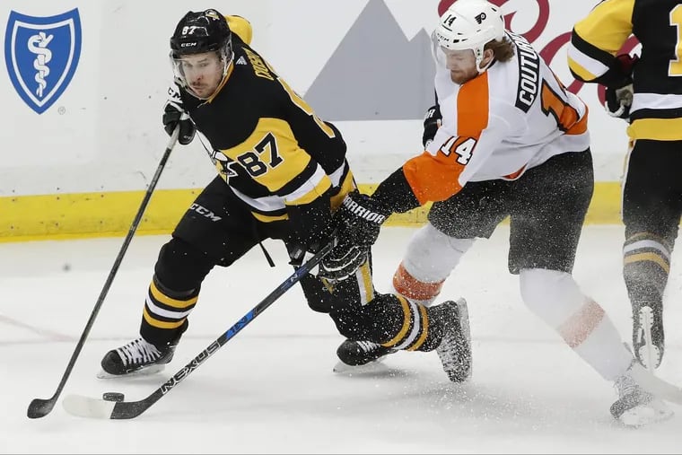 Sean Couturier (right) defending Pittsburgh’s Sidney Crosby in the Penguins’ 5-4 overtime win over the visiting Flyers on March 25.