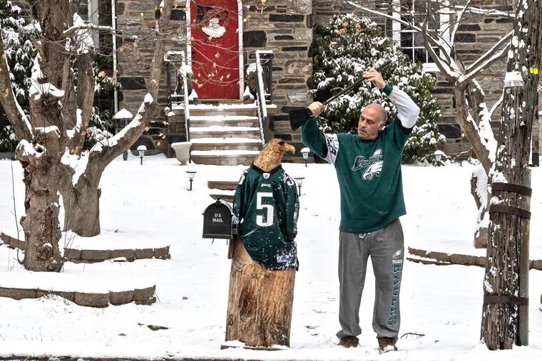 Eagles fan, Art Violi brushes the snow from his eagle wood carving during a snow winter day in Springfield, Pa. Sunday, January 13, 2019.  JOSE F. MORENO / Staff Photographer