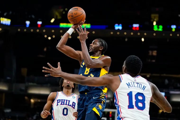 Indiana Pacers forward Justin Holiday (8) shoots over Philadelphia 76ers guard Shake Milton (18) during the second half of Saturday's game in Indianapolis.