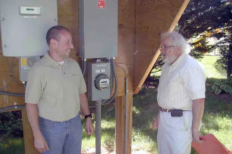 Guy Jacquet (left), the owner of Solar Pro, installed the system belonging to Edward Frankel. The meter measures the output from Frankel's solar array.