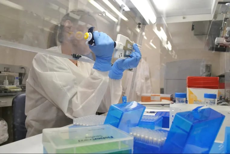 A photo lab technician extracts DNA for whole genome sequencing.