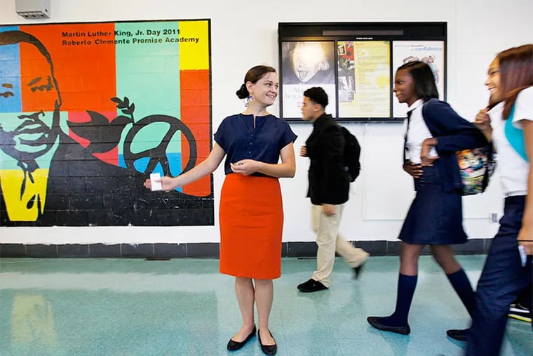 Breanne Lucy, a first-year teacher in the Philadelphia schools, directs freshman students from the cafeteria to the auditorium to begin their first day at the new LINC school.