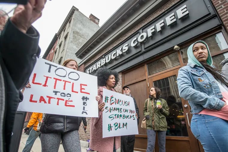Soren McClay, left, and her stepmother, Donn T, right, hold up signs of protest during the local Black Lives Matter demonstration in front of the Starbucks at 18th and Spruce on Sunday April 15, 2018. Protesters demonstrated outside the Starbucks at the center of this storm Sunday, and plan to return Monday at peak time: 7 to 10 a.m. Organizers are calling for the employee who called police and the arresting officers to be fired<br/>
 MICHAEL BRYANT /Staff Photographer