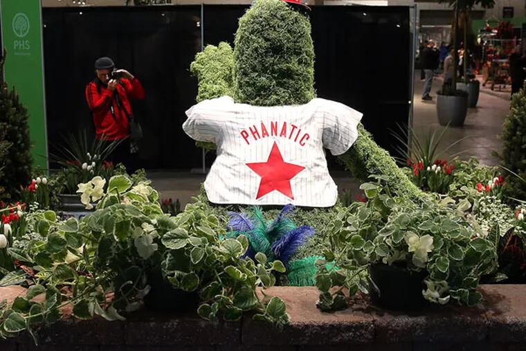 Jim Ethridge, of Middletown, Del., takes a picture of a Phillie Phanatic topiary during the Philadelphia Flower Show's private preview at the convention center on Feb. 27, 2015. ( DAVID MAIALETTI / Staff Photographer )