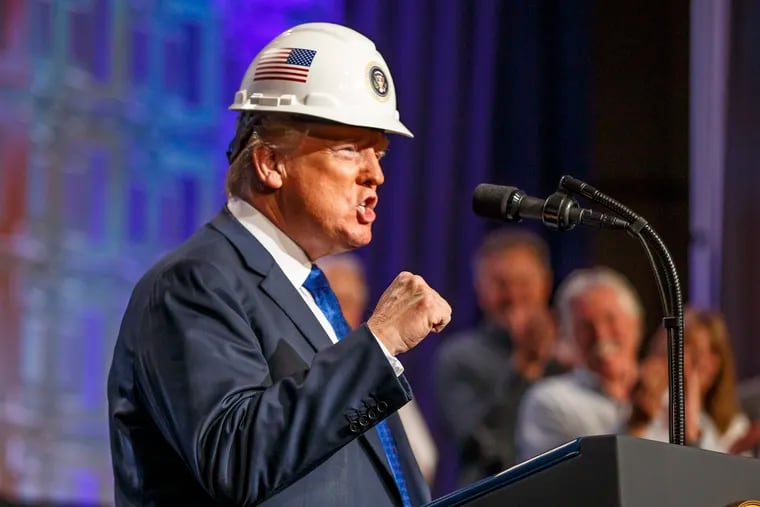 President Donald Trump placed a hard hat on his head with the Presidential Seal on it and struck a pose for the audience of National Electrical Contractors Association members at the Philadelphia Convention Center on October 2, 2018.