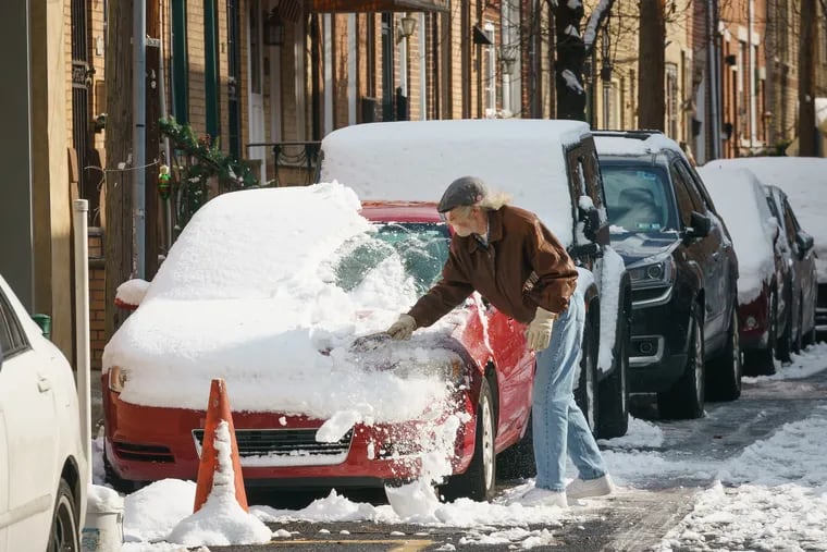 Jim Peak clears snow off of his car in South Philadelphia last week. He might have to do it again during the weekend.