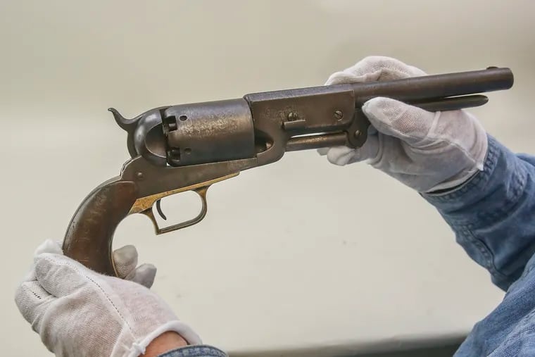 Tim Hollinger, an auctioneer with Alderfer Auctions in Hatfield, displays a rare Colt  Walker pistol, one of only 37 remaining,  The revolver was discovered by a family in Montgomery County as they cleaned out their elderly father's home.