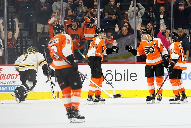 Flyers center Sean Couturier celebrates his second-period goal with left wing James van Riemsdyk (25) and right wing Travis Konecny (11).
