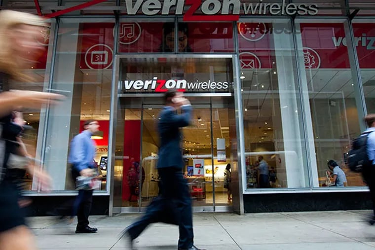 Pedestrians walk past a Verizon Wireless store in New York, U.S., on Tuesday, Sept. 3, 2013. Verizon Communications Inc. and Vodafone Group Plc announced over the weekend that the U.S. communications giant will acquire its U.K.-based partner's stake in Verizon Wireless. The $130 billion deal, one of the largest in history, ends a decades-long partnership and gives Verizon full control over a wireless company that throws of more than $20 billion in operating income each year. (Jin Lee/Bloomberg)