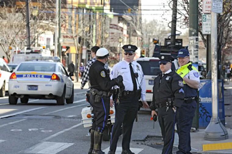 Philadelphia police sgt. Charlie Marsden (center in white shirt), and other police on hand to avert  a possible flash mob gathering yesterday. (Clem Murray / Staff Photographer )