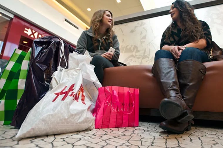 Sisters Holly and Colleen Skowronski, of Palmyra, rest after shopping for five hours at Cherry Hall Mall during Black Friday. ( RON TARVER / Staff Photographer )