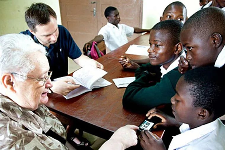 Holy Family's Sister Francesca Onley shows students in Newala, Tanzania, how to use a handheld computer and phone.