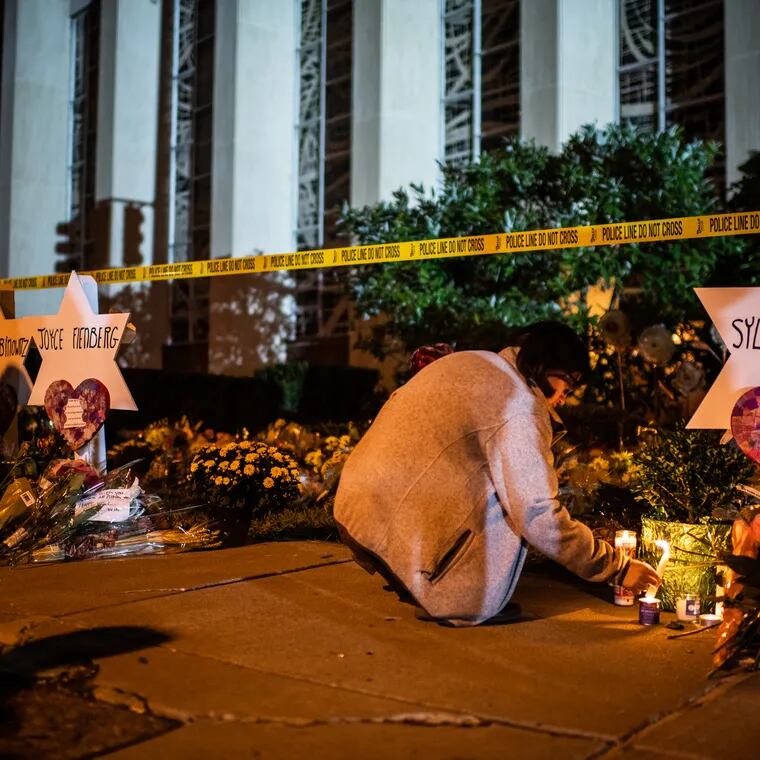 A woman leaves a candle in front of the Tree of Life synagogue in Pittsburgh on Oct. 29, 2018. Eleven people were killed during a mass shooting at the synagogue two days earlier.