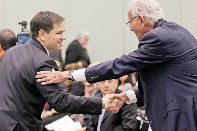Sen. Marco Rubio (left) shakes hands with Norman Braman, a supporter of his presidential campaign. (LYNNE SLADKY / ASSOCIATED PRESS)