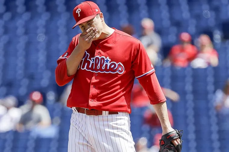 Phillies pitcher Jerad Eickhoff wipes his face after giving up an RBI double to the Braves’ Nick Markakis.