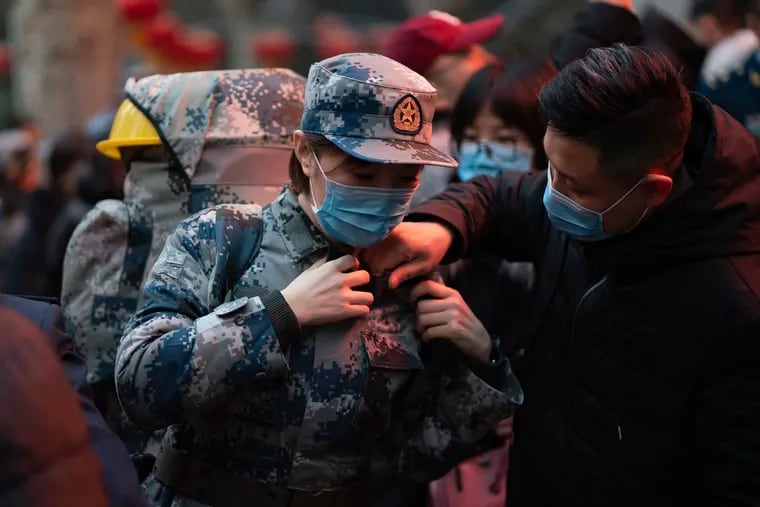 In this photo taken Jan 24, 2020 and released by Xinhua News Agency, a military medic from the Air Force Medical University prepares to leave for Wuhan from Xi'an, capital of northwestern China's Shaanxi Province. The Chinese military dispatched medical staff, some with experience in past outbreaks including SARS and Ebola, to help treat the many patients hospitalized with viral pneumonia, Xinhua reported.