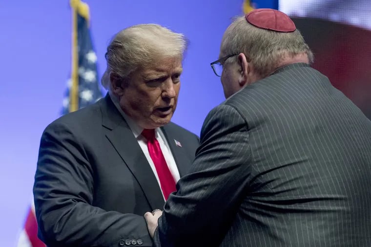 President Donald Trump embraces Rabbi Benjamin Sendrow after he prays at the 91st annual Future Farmers of America Convention and Expo at Bankers Life Fieldhouse in Indianapolis, Saturday, Oct. 27, 2018, following a shooting in a Pittsburgh synagogue.