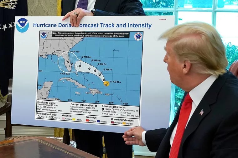President Donald Trump references a map held by acting Homeland Security Secretary Kevin McAleenan, featuring a forecast from Aug. 29 that appears to have been altered by a black marker to extend the hurricane's range to include Alabama.