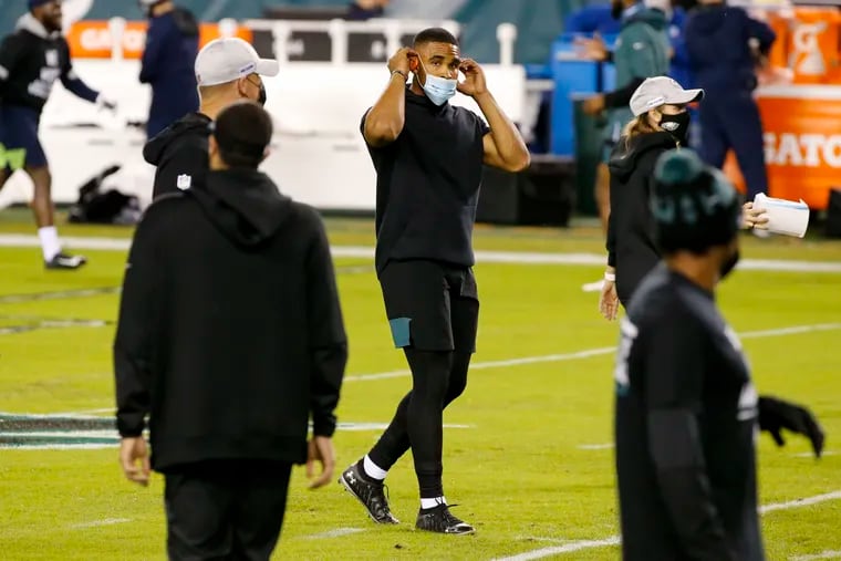 Eagles quarterback Jalen Hurts puts on a face mask before the Eagles' game against the Seattle Seahawks in November.