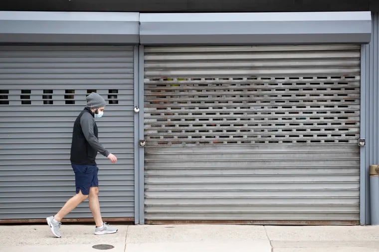 A warm Saturday afternoon meant shorts, as a pedestrian walks by closed stores on 8th Street in Philadelphia on April 25, 2020. Pennsylvania is preparing to open some areas soon, but it's expected that Philadelphia will reopen much more slowly amid the coronavirus pandemic.
