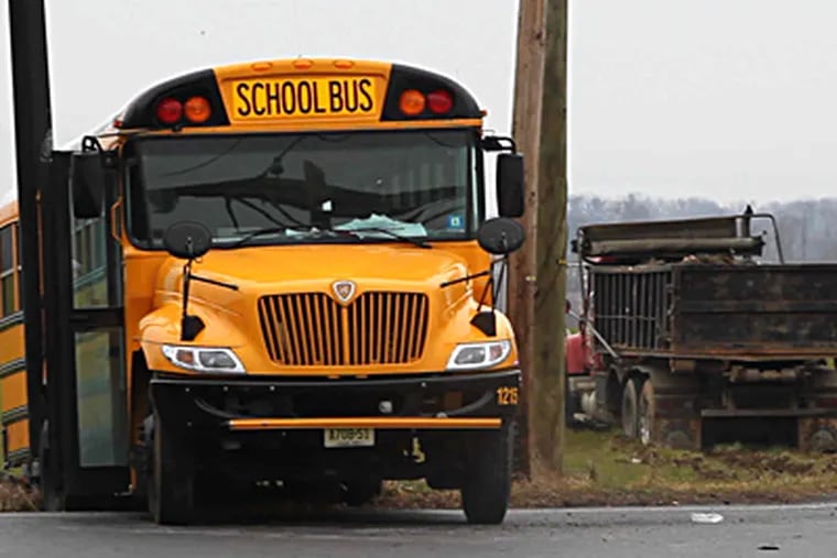 An 11-year-old triplet was killed, and her two sisters and another boy were critically injured, Thursday morning when a dump truck (right) slammed into their school bus in rural Burlington County. (David M. Warren / Staff Photographer)