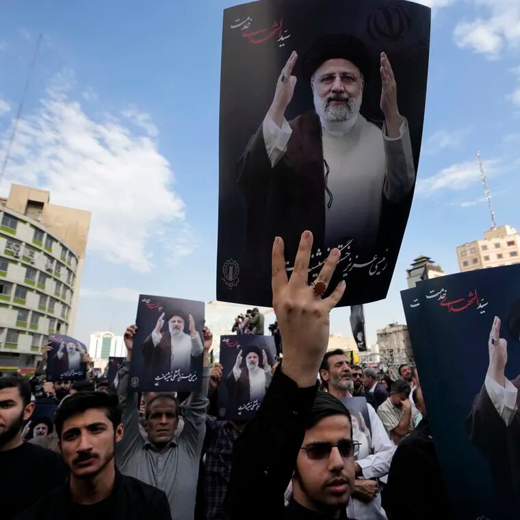 People hold up posters of Iranian President Ebrahim Raisi during a mourning ceremony for him at Vali-e-Asr square in downtown Tehran, Iran, on Monday, May 20, 2024.
