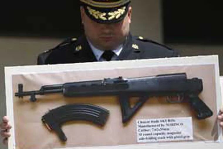 Philadelphia Police Deputy Commissioner Thomas Wright holds a
photograph of the gun used in the fatal shooting of Sgt. Stephen Liczbinski. (David Maialetti/Daily News)