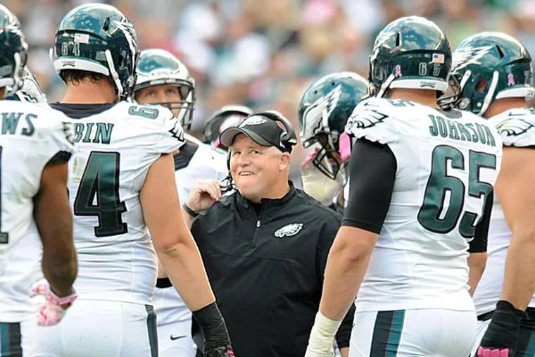Chip Kelly and his Eagles players huddle during a game. (Clem Murray/Staff Photographer)