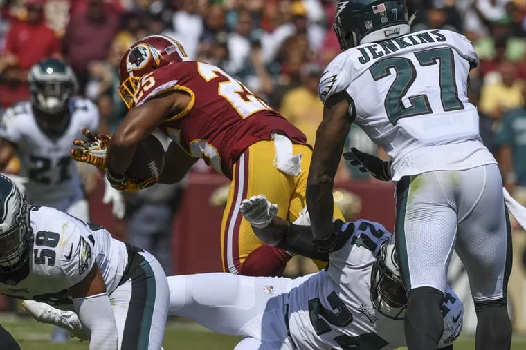 Eagles defenders Jordan Hicks (left), Corey Graham (center) and Malcolm Jenkins bounce off Washington running back Chris Thompson as he scores on a 29-yard 2nd quarter touchdown pass in Washington’s 30-17 loss at FedEx Field in Landover, MD September 10, 2017.