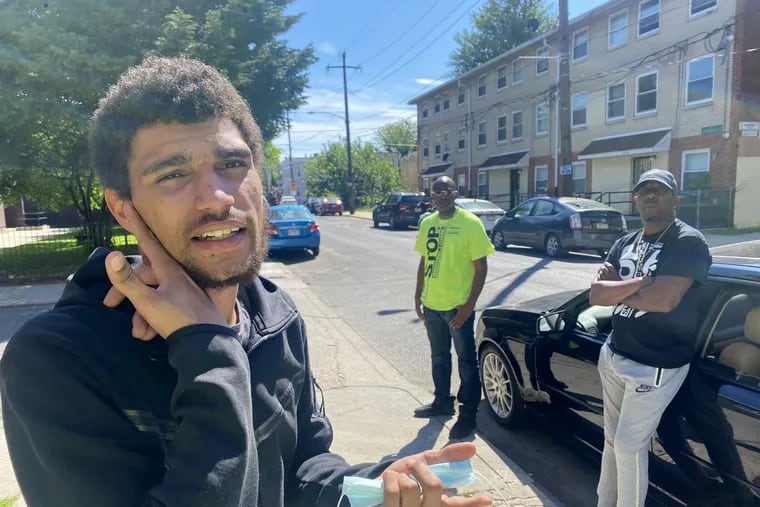 Hassan Butler (left), describing his injuries as a result of being shot 18 times. Ronald Putman and Mitchell Robinson, of Philadelphia Ceasefire, listen.