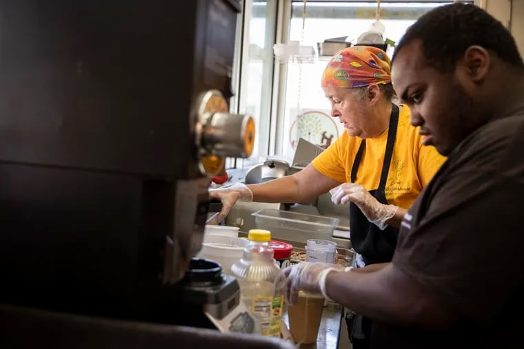 Chef Peg Botto and Dorrell Parker work in the kitchen at Cosmic Cafe at 1 Boathouse Row in Philadelphia.